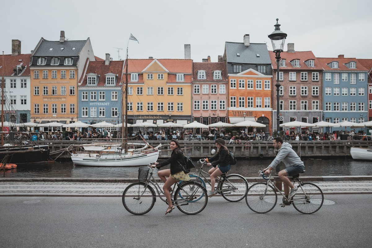 Denmark Startup Visa Nyhavn harbour in Copenhagen with cyclists passing by